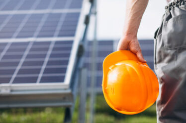 Homem trabalhador perto dos painéis solares