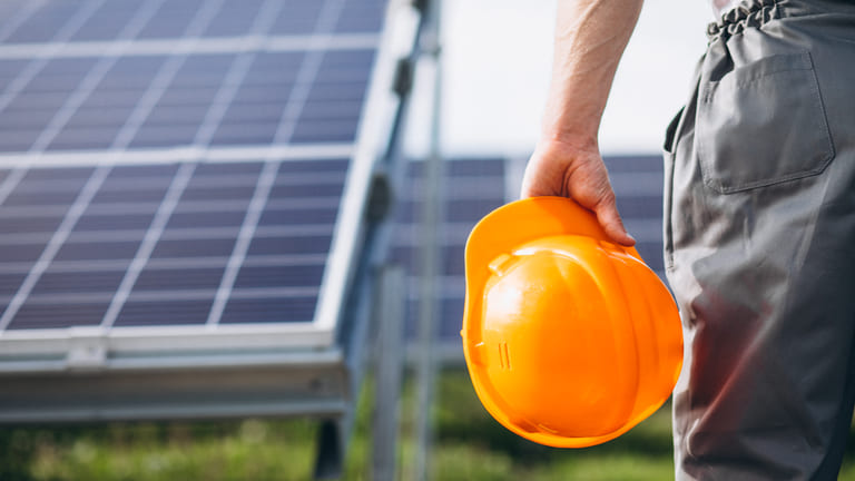 Homem trabalhador perto dos painéis solares